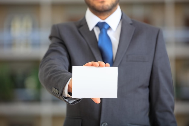 Empresario sosteniendo una tarjeta en blanco