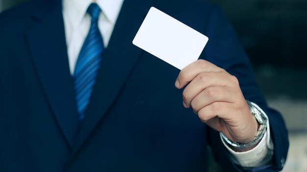 Empresario sosteniendo una tarjeta de visita blanca