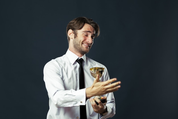 Foto empresario sosteniendo el trofeo de la copa de oro