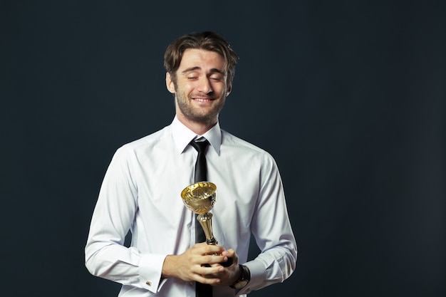 Empresario sosteniendo el trofeo de la copa de oro