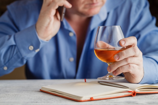 Empresario sosteniendo un vaso de whisky, de cerca