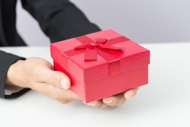 Empresario sostiene la caja de regalo roja
