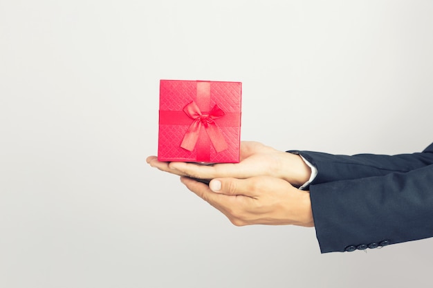 Empresario sostiene la caja de regalo roja