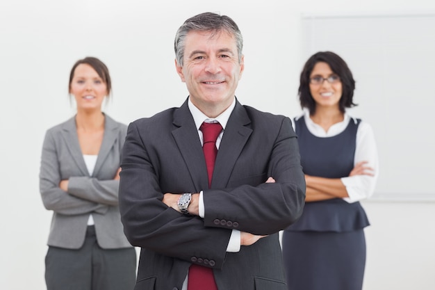 Empresario y su equipo sonriendo de pie