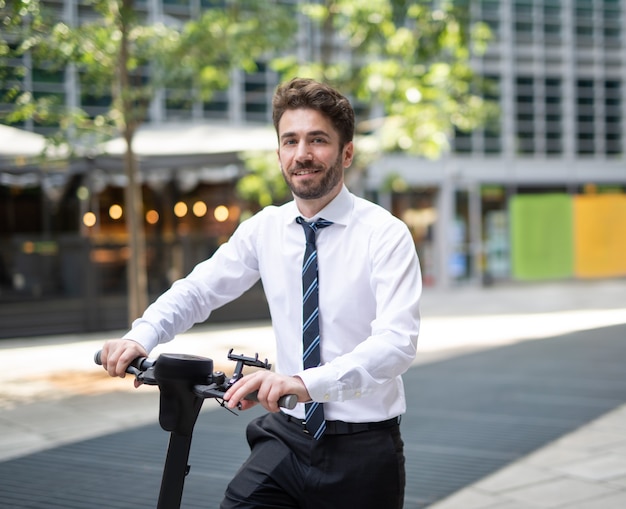 Empresario con su scooter eléctrico en una ciudad