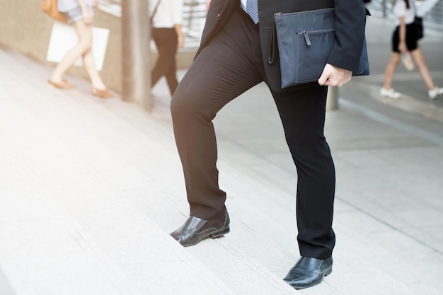 Empresario subiendo las escaleras luchando contra obstáculos Subir al concepto de finalización exitosa