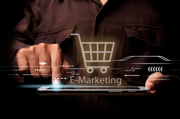 empresario con una tableta tocando la pantalla con un diseño de carrito de compras y texto de marketing electrónico