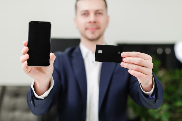 Foto empresario con tarjeta de crédito y teléfono móvil