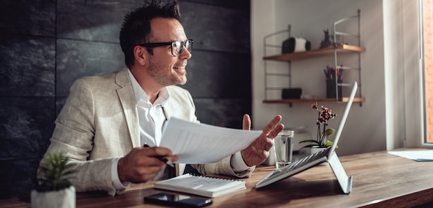 Empresário tendo reunião on-line em seu escritório