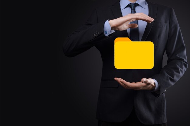 El empresario tiene un icono de carpeta. El sistema de gestión de documentos o la configuración de DMS por parte de un consultor de TI con una computadora moderna están buscando información de gestión y archivos corporativos. Procesamiento de negocios,