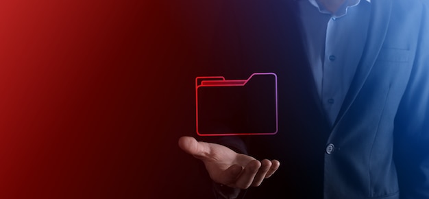 El empresario tiene un icono de carpeta. El sistema de gestión de documentos o la configuración de DMS por parte de un consultor de TI con una computadora moderna están buscando información de gestión y archivos corporativos. Procesamiento de negocios,