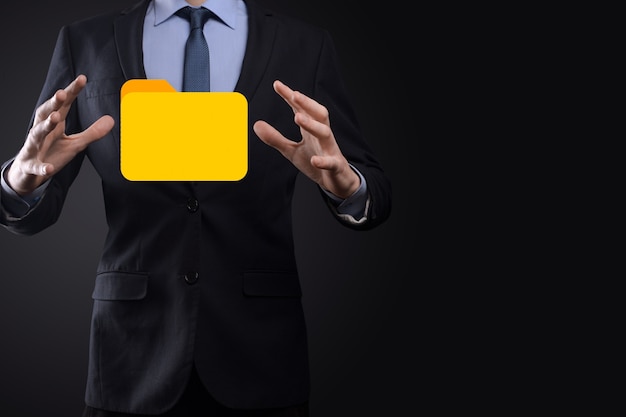 El empresario tiene un icono de carpeta. El sistema de gestión de documentos o la configuración de DMS por parte de un consultor de TI con una computadora moderna están buscando información de gestión y archivos corporativos. Procesamiento de negocios,