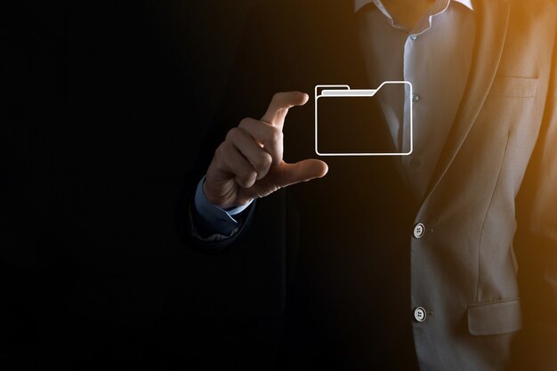 El empresario tiene un icono de carpeta. El sistema de gestión de documentos o la configuración de DMS por parte de un consultor de TI con una computadora moderna están buscando información de gestión y archivos corporativos. Procesamiento de negocios,