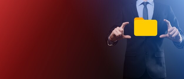 El empresario tiene un icono de carpeta. El sistema de gestión de documentos o la configuración de DMS por parte de un consultor de TI con una computadora moderna están buscando información de gestión y archivos corporativos. Procesamiento de negocios,