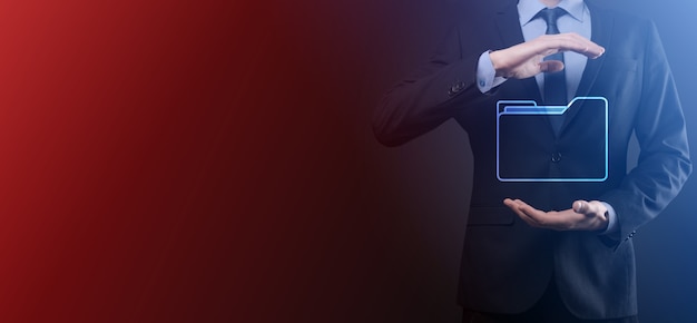 El empresario tiene un icono de carpeta. El sistema de gestión de documentos o la configuración de DMS por parte de un consultor de TI con una computadora moderna están buscando información de gestión y archivos corporativos. Procesamiento de negocios,