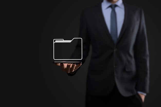 El empresario tiene un icono de carpeta. El sistema de gestión de documentos o la configuración de DMS por parte de un consultor de TI con una computadora moderna están buscando información de gestión y archivos corporativos. Procesamiento de negocios,