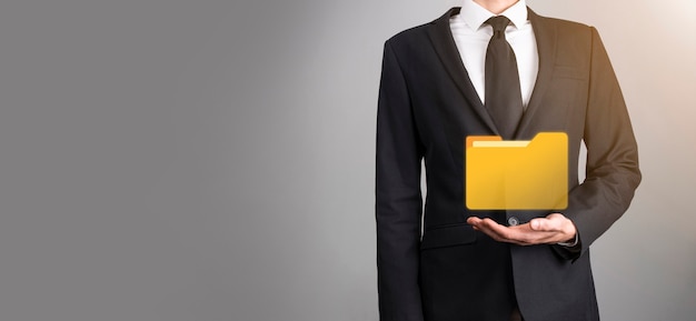 El empresario tiene un icono de carpeta. El sistema de gestión de documentos o la configuración de DMS por parte de un consultor de TI con una computadora moderna están buscando información de gestión y archivos corporativos. Procesamiento de negocios,
