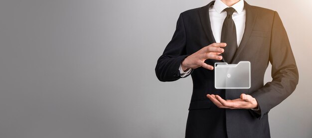El empresario tiene un icono de carpeta. El sistema de gestión de documentos o la configuración de DMS por parte de un consultor de TI con una computadora moderna están buscando información de gestión y archivos corporativos. Procesamiento de negocios,
