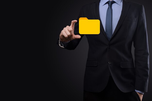 El empresario tiene un icono de carpeta. El sistema de gestión de documentos o la configuración de DMS por parte de un consultor de TI con una computadora moderna están buscando información de gestión y archivos corporativos. Procesamiento de negocios,