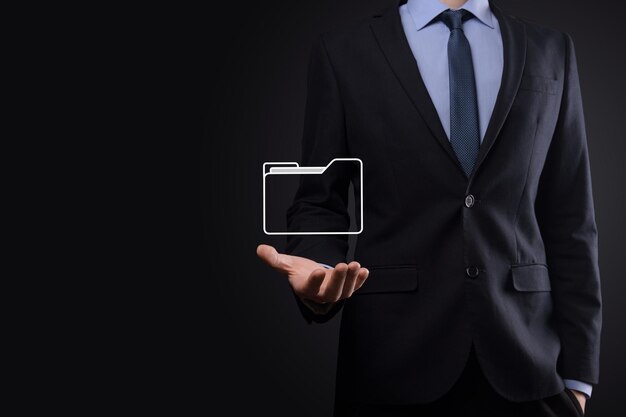 El empresario tiene un icono de carpeta. El sistema de gestión de documentos o la configuración de DMS por parte de un consultor de TI con una computadora moderna están buscando información de gestión y archivos corporativos. Procesamiento de negocios,