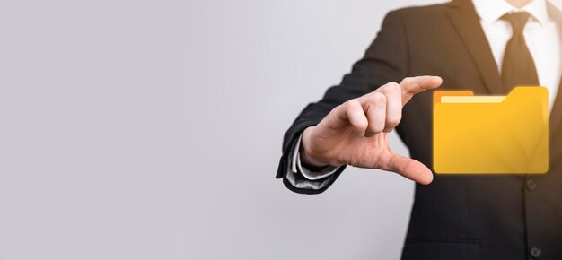 El empresario tiene un icono de carpeta. El sistema de gestión de documentos o la configuración de DMS por parte de un consultor de TI con una computadora moderna están buscando información de gestión y archivos corporativos. Procesamiento de negocios,