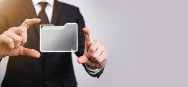 El empresario tiene un icono de carpeta. El sistema de gestión de documentos o la configuración de DMS por parte de un consultor de TI con una computadora moderna están buscando información de gestión y archivos corporativos. Procesamiento de negocios,