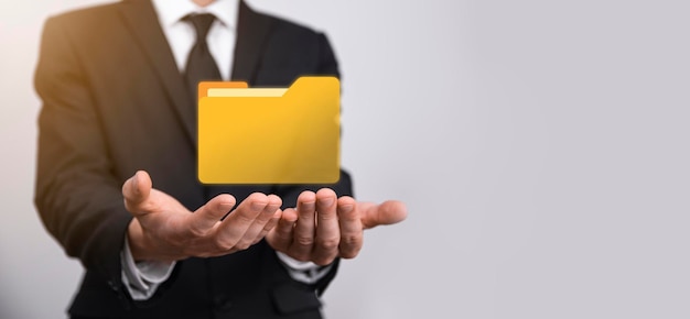 El empresario tiene un icono de carpeta. El sistema de gestión de documentos o la configuración de DMS por parte de un consultor de TI con una computadora moderna están buscando información de gestión y archivos corporativos. Procesamiento de negocios,