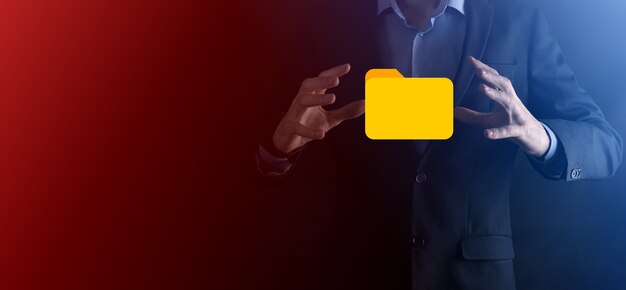El empresario tiene un icono de carpeta. El sistema de gestión de documentos o la configuración de DMS por parte de un consultor de TI con una computadora moderna están buscando información de gestión y archivos corporativos. Procesamiento de negocios,