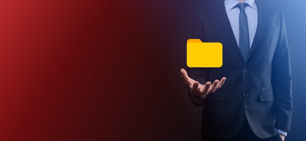 El empresario tiene un icono de carpeta. El sistema de gestión de documentos o la configuración de DMS por parte de un consultor de TI con una computadora moderna están buscando información de gestión y archivos corporativos. Procesamiento de negocios,