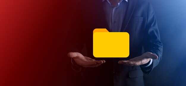 El empresario tiene un icono de carpeta. El sistema de gestión de documentos o la configuración de DMS por parte de un consultor de TI con una computadora moderna están buscando información de gestión y archivos corporativos. Procesamiento de negocios,