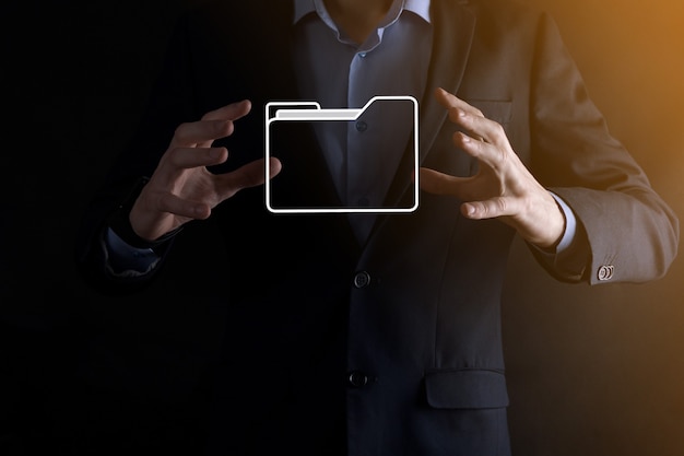 El empresario tiene un icono de carpeta. El sistema de gestión de documentos o la configuración de DMS por parte de un consultor de TI con una computadora moderna están buscando información de gestión y archivos corporativos. Procesamiento de negocios,
