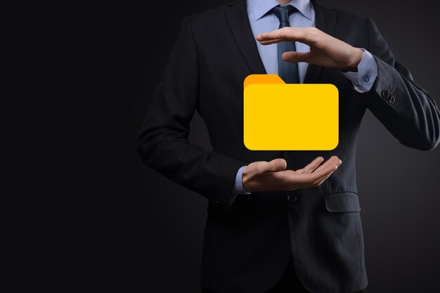 El empresario tiene un icono de carpeta. El sistema de gestión de documentos o la configuración de DMS por parte de un consultor de TI con una computadora moderna están buscando información de gestión y archivos corporativos. Procesamiento de negocios,