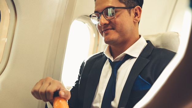 El empresario tiene jugo de naranja servido por una azafata en avión