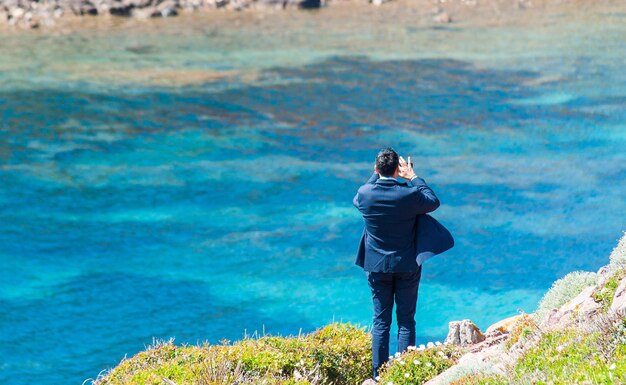 Empresario toma fotos con smartphone en la costa