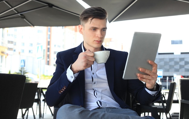 Empresário tomando café e lendo notícias no café.