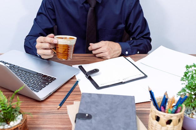 Empresario tomando café en su escritorio