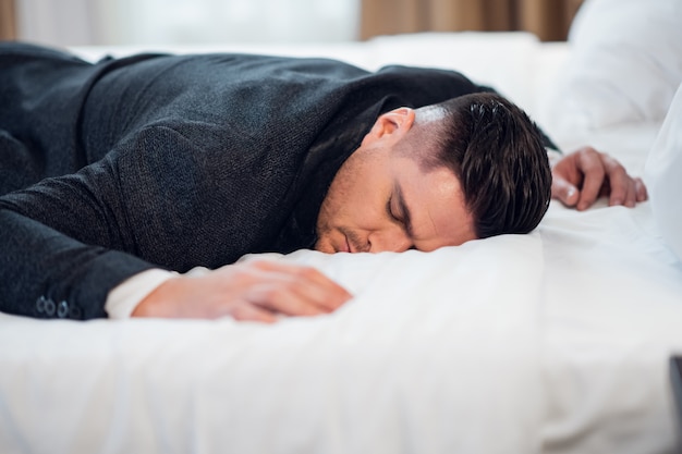 Un empresario tomando una pequeña siesta en una habitación de hotel