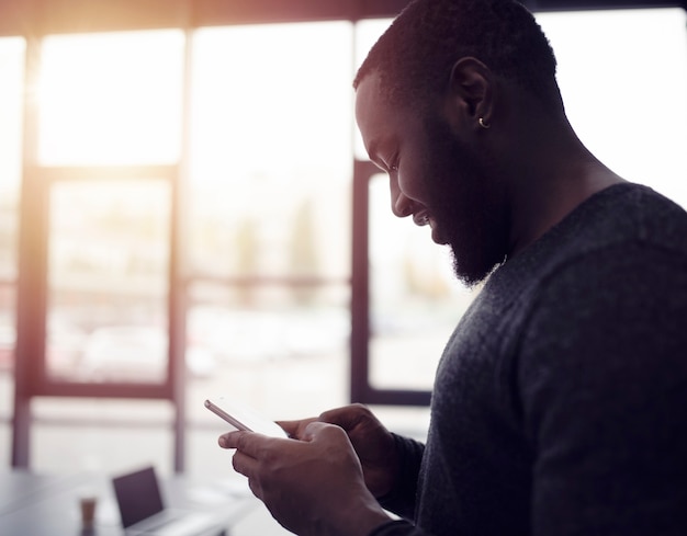 El empresario trabaja con su teléfono inteligente en la oficina