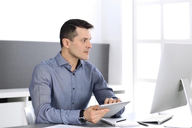 Empresario trabajando con computadora en la oficina moderna. Captura de cabeza de empresario masculino o director de empresa en el lugar de trabajo. Concepto de negocio.