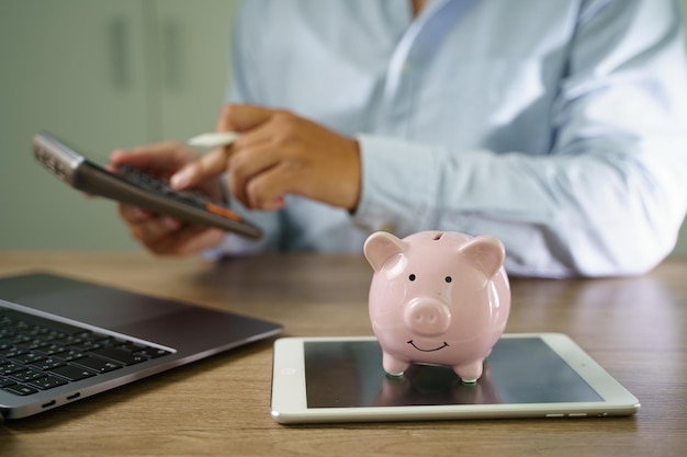 Foto empresario trabajando en escritorio oficina finanzas contabilidad ahorrar dinero alcancía con negocios