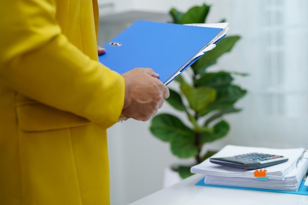 Empresario trabajando y preparando datos de informes de papeleo para analizar información en carpeta de archivos en la oficina