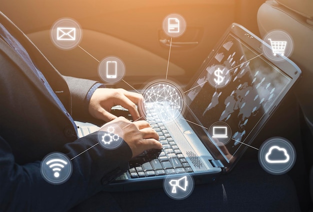 Empresario trabajando en su computadora portátil mientras está sentado en el concepto de conexión carNetwork