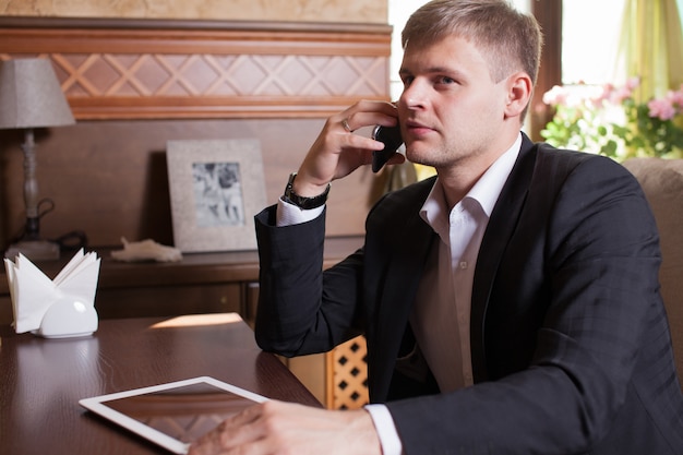 Empresario trabajando en una tableta en un café