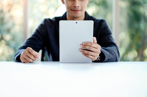 Empresario trabajando en tableta digital en la oficina. Sentado en el escritorio.