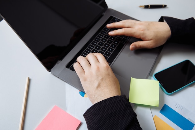 Empresário, trabalhando com o laptop na mesa do escritório.