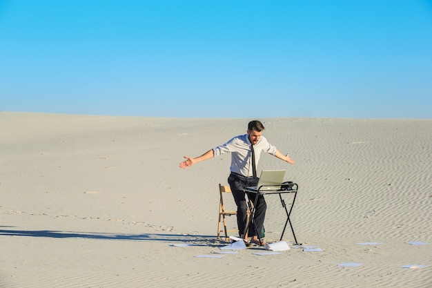 Empresário trabalhando e usando um laptop no deserto