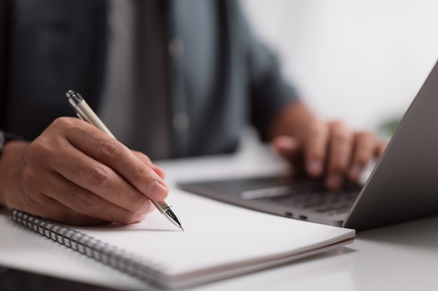 Empresário trabalhando em sua mesa com seu laptop e documentos no escritório.