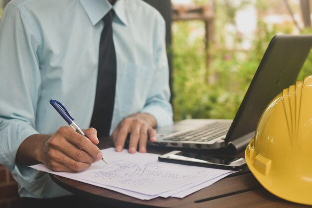 Empresário trabalhando num café escreve em um documento em papel