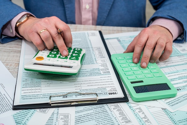 Empresario de traje azul resume los resultados anuales de la campaña y completa una declaración de impuestos 1040