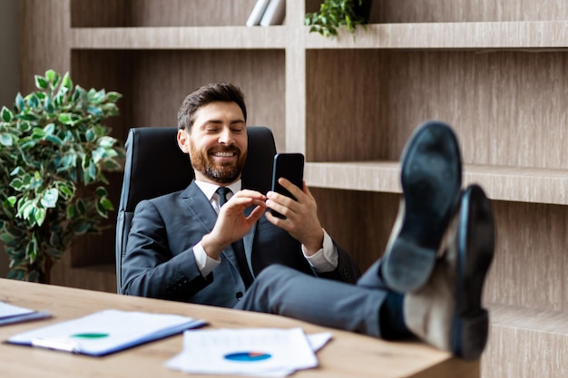 Empresario con traje elegante sentado en el escritorio de la computadora en la oficina